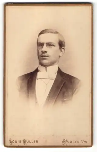 Fotografie Louis Müller, Hameln a/W, Portrait junger Herr in Abendgarderobe mit Zwicker