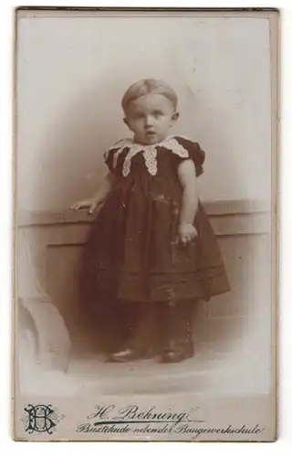 Fotografie H. Behning, Buxtehude, Portrait süsses blondes Mädchen im schwarzen Kleid mit weisser Spitze