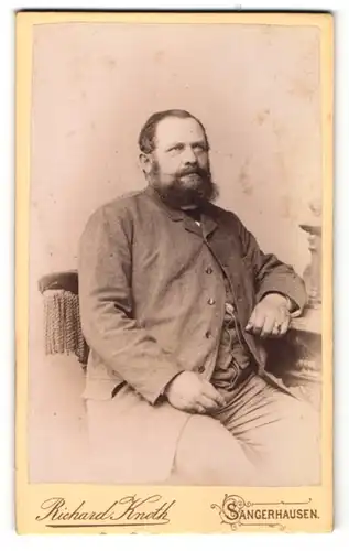 Fotografie Richard Knoth, Sangerhausen, Portrait Mann mit Vollbart auf einem Stuhl sitzend
