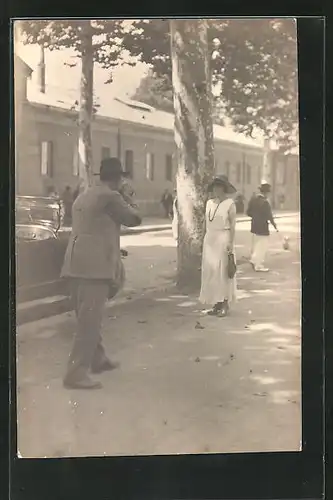AK Fotoapparat, Mann fotografiert Frau im weissen Kleid mit Hut