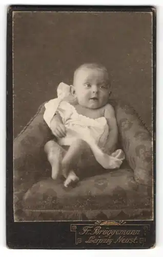 Fotografie Fr. Brüggemann, Leipzig Neust., Süsses Baby auf einem Sessel
