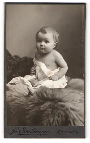 Fotografie Fr. Struckmeyer, Göttingen, Süsser Säugling auf einem Fell