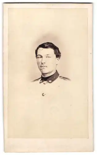 Fotografie Theodor Schlüter, Pinneberg, Portrait dunkelhaariger Soldat in interessanter Uniform mit Sternen