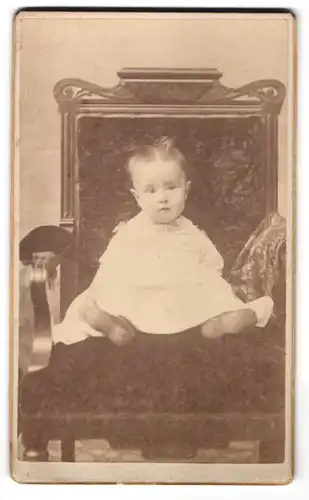 Fotografie unbekannter Fotograf und Ort, Portrait Kleinkind auf Sitzmöbel