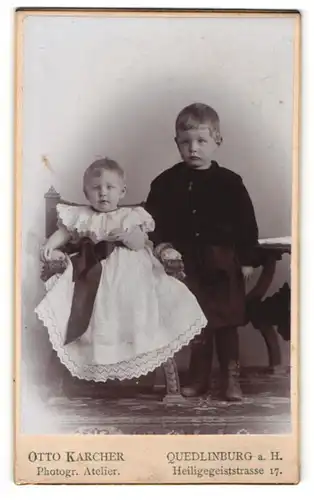 Fotografie Otto Karcher, Quedlinburg a. H., Kleinkind mit Kleid und Schleife, kleiner Junge