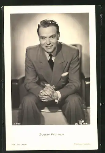 AK Schauspieler Gustav Fröhlich freudig auf einem Stuhl sitzend
