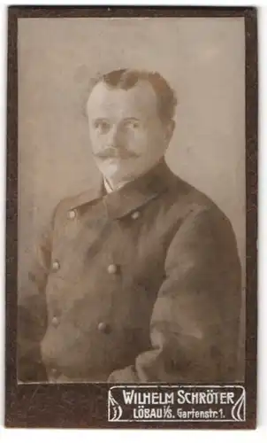 Fotografie Wilhelm Schröter, Löbau i / S., Portrait Herr mit Zwirbelbart im Mantel