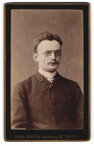 Fotografie Gustav Schlüter, Goslar a/H, Portrait junger Mann mit Zwicker und zeitgenöss. Frisur