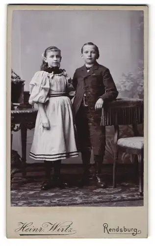 Fotografie Heinrich Wirtz, Rendsburg, Mädchen mit Puffärmelkleid, Junge in Anzug mit kurzen Hosen