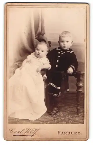 Fotografie Carl Wolf, Harburg, Junge in Matrosenanzug, Kleinkind in langem Kleid
