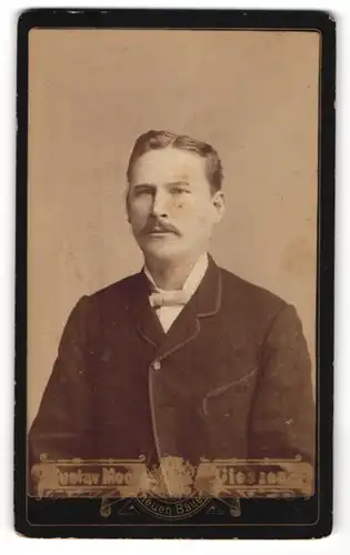 Fotografie Gustav Mook, Giessen, Portrait bürgerlicher Herr mit Schnurrbart und Fliege im Anzug