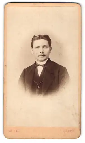 Fotografie Pa. Uhl, Giessen, Portrait bürgerlicher Herr mit Oberlippenbart und Fliege im Anzug
