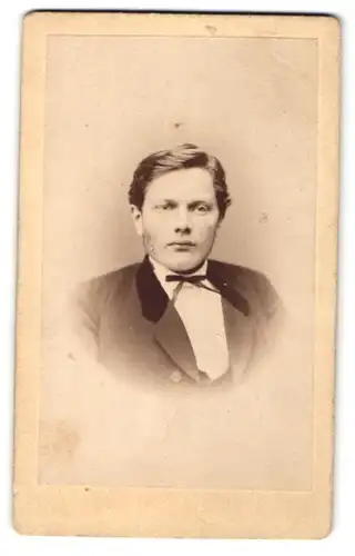 Fotografie C. Huster, Siegen, Portrait junger Mann mit Fliege im Anzug