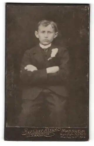 Fotografie E. Kregeloh, Mannheim, Portrait hübscher Knabe mit verschränkten Armen im Anzug
