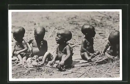 AK Afrikanische nackte Kleinkinder sitzen weinend in der Steppe, afrikanische Volkstypen