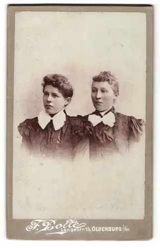 Fotografie F. Bolte, Oldenburg i / Gr., Portrait zwei hübsche junge Damen in eleganten Kleidern mit zurückgeb. Haar