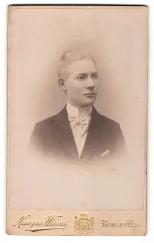Fotografie Haeyn-Wilms, Bielefeld, Portrait junger charmanter Herr mit Fliege im Anzug