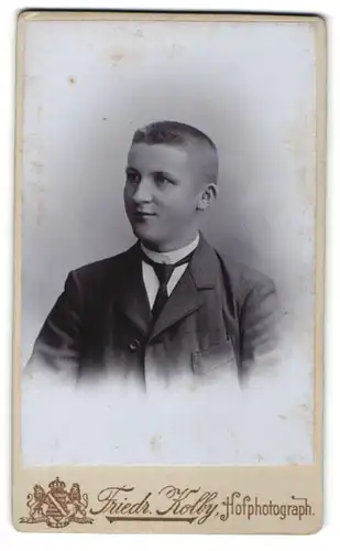 Fotografie Friedr. Kolby, Zwickau i / S., Portrait junger verschmitzt lächelnder Herr mit Krawatte im Anzug
