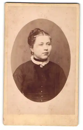 Fotografie Carl Wolf, Celle, Portrait junge lächelnde Dame mit Hochsteckfrisur u. Amulett in zeitgenössischer Kleidung