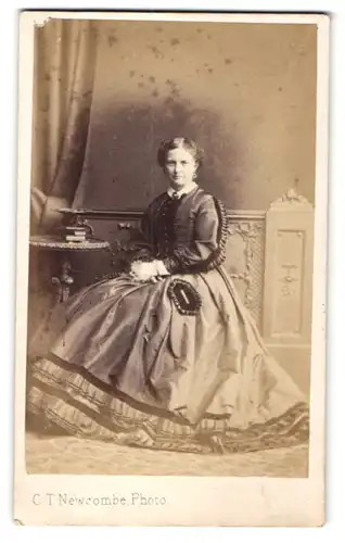 Fotografie C. T. Newcombe, London, Dame in eleganten Kleid mit Handtasche
