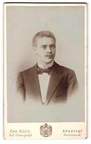 Fotografie Chr. Beitz, Arnstadt, Portrait junger Herr mit Zwirbelbart u. Fliege im Anzug