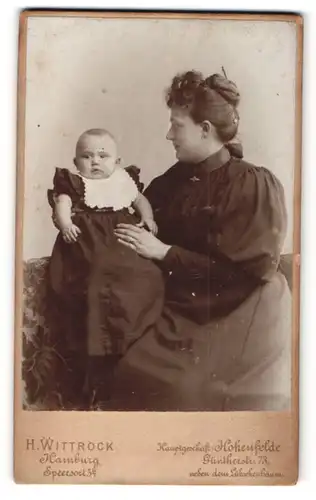 Fotografie H. Wittrock, Hamburg, Portrait lächelnde Mutter mit Hochsteckfrisur und Baby im Arm