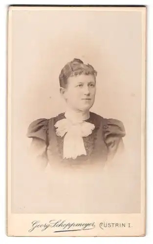 Fotografie Georg Schloppmeyer, Cüstrin, Portrait lächelnde Dame mit zurückgebundenem Haar im eleganten Kleid