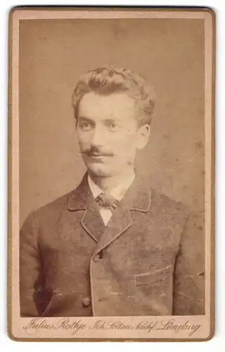 Fotografie Julius Rathje, Lüneburg, Portrait junger Herr mit zurückgekämmtem Haar und Oberlippenbart
