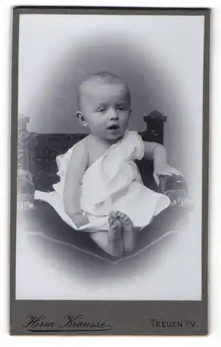 Fotografie Herm. Krausse, Treuen i / V., Portrait niedliches Baby im weissen Kleid auf Stuhl sitzend