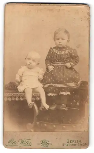 Fotografie Otto Witte, Berlin, Portrait kleines Mädchen im hübschen Kleid und Baby auf Hockern sitzend