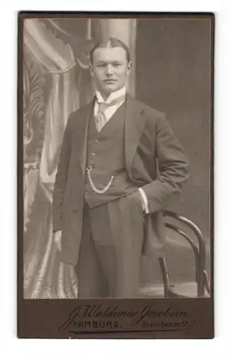 Fotografie J. Waldemar Jacobsen, Hamburg, Portrait charmanter Herr mit Mittelscheitel und Krawatte im Anzug