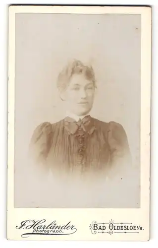 Fotografie J. Harländer, Bad Oldesloe i. / H., Portrait lächelnde Dame mit zeitgenössischer Frisur im eleganten Kleid