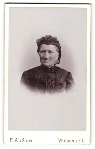 Fotografie F. Ahlborn, Winsen a. d. L., Portrait ältere lächelnde Dame mit Haube im eleganten Kleid