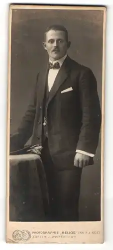 Fotografie Helios v. F. J. Köst, Zürich, Portrait eleganter Herr im Anzug mit Fliege