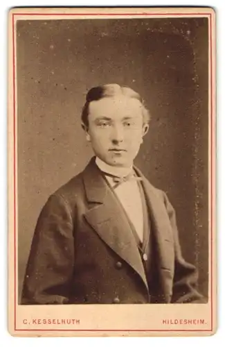 Fotografie C. Kesselhuth, Hildesheim, Portrait junger charmanter Herr mit Fliege im Anzug