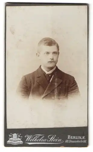 Fotografie Wilhelm Stein, Berlin N., Portrait junger Herr mit zeitgenöss. Frisur u. Krawatte im Anzug