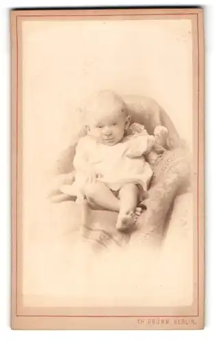 Fotografie Th. Prümm, Berlin, Kleinkind mit nackten Beinen in Hemdchen, lächelnd