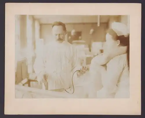 Fotografie S.F. Meissl, Berlin, Arzt entnimmt Flüssigkeit, Krankenschwester fixiert den Patient