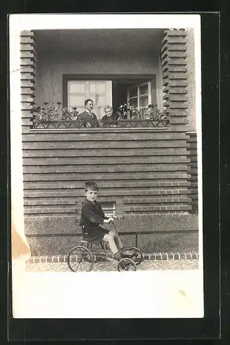 Foto-AK Kleiner Junge mit Dreirad vor einem Fenster