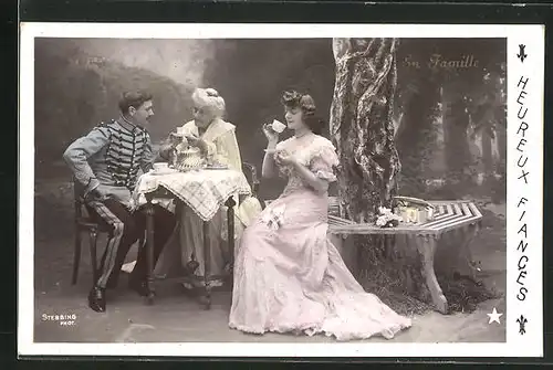 Foto-AK Stebbing: En Famille, Herr in Uniform und Grossmutter sitzen am Kaffeetisch mit Dame unter einem Baum