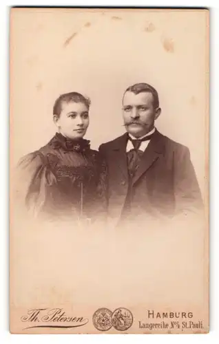 Fotografie Th. Petersen, Hamburg, Portrait bürgerliches Paar mit zeitgenössischen Frisuren in hübscher Kleidung