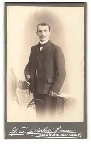 Fotografie T. J. Dickopf, Siegburg, Portrait charmanter Herr mit Schnauzbart u. Fliege im Anzug