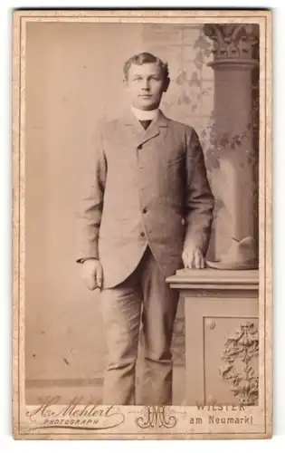 Fotografie H. Mehlert, Wilster, junger Mann mit Stehkragen in zugeknöpften Anzug