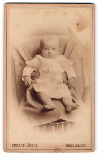 Fotografie Eduard Lösche, Rudolstadt, Portrait niedliches Baby im weissen Kleid auf Sessel sitzend