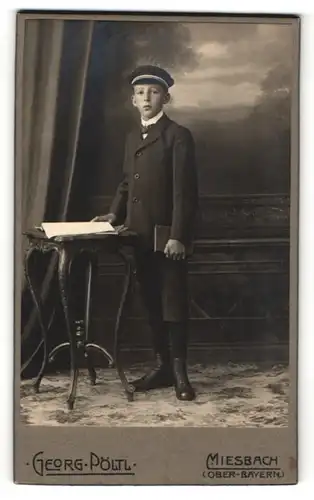 Fotografie Georg Pöltl, Miesbach, Junge in Anzug mit Mütze und kurzen Hosen mit Buch in der Hand