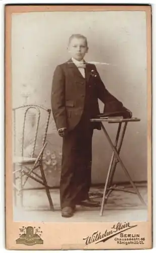 Fotografie Wilhelm Stein, Berlin, Portrait blonder frecher Bube mit Melonenhut und Handschuhen im Anzug