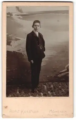 Fotografie Adolf Koestler, München, Portrait dunkelhaariger Knabe im eleganten Anzug vor einer Gebirgsleinwand