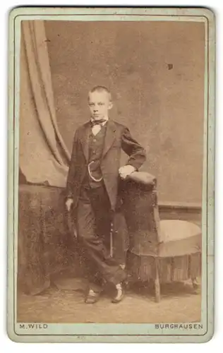 Fotografie M. Wild, Burghausen, Junge in Anzug lehnt an Stuhl
