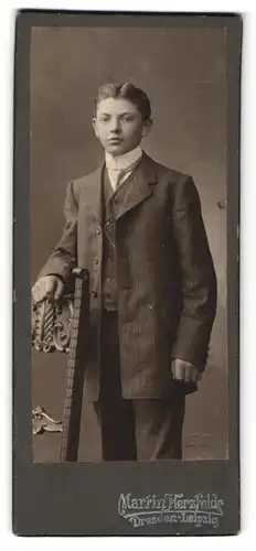 Fotografie Martin Herzfelde, Dresden, Leipzig, Portrait junger Herr mit Krawatte im Anzug an Stuhl gelehnt
