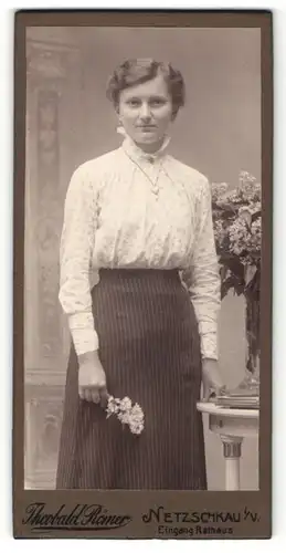 Fotografie Theobald Römer, Netzschkau i / V., Portrait junge Dame in modischer Kleidung mit Blumen an Tisch gelehnt